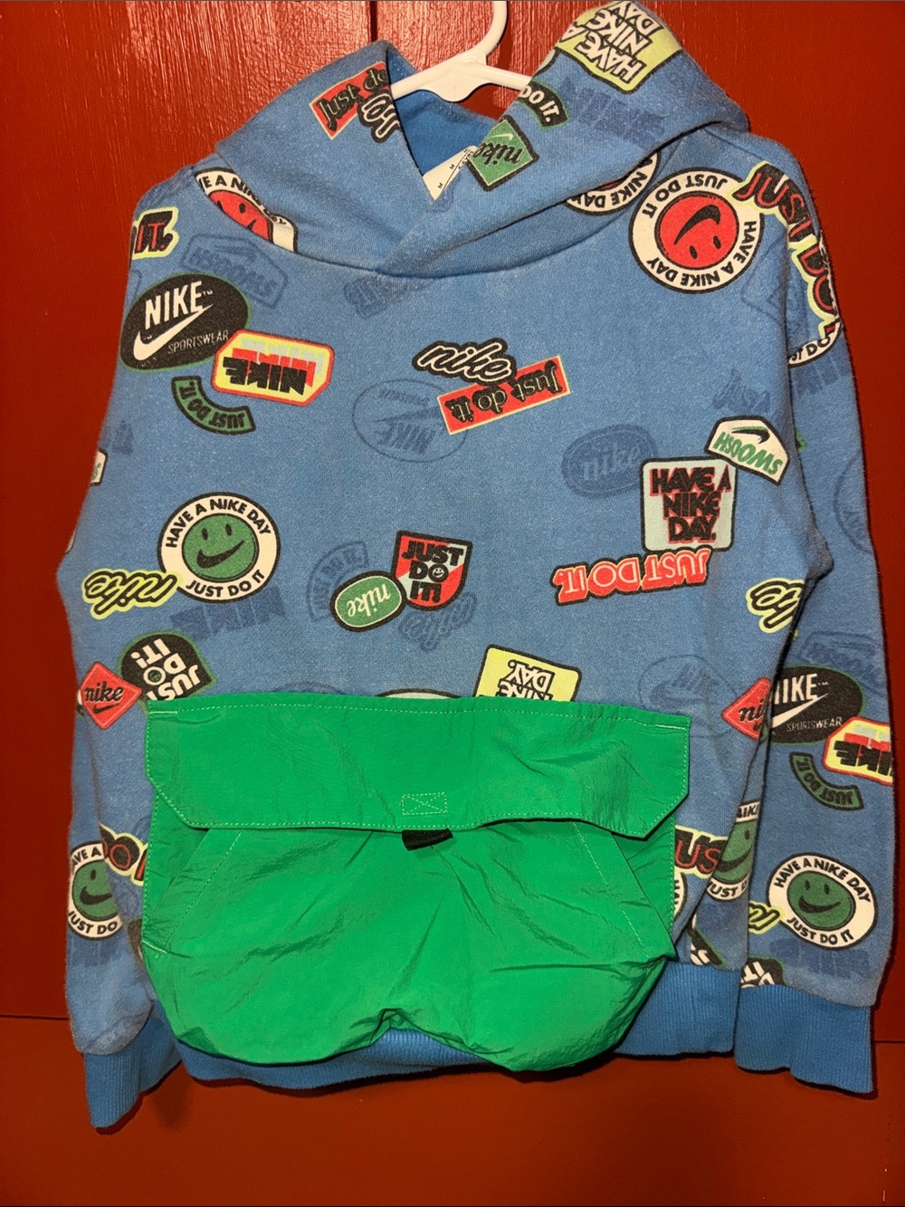 Nike Kids Blue Hoodie with Green Front Pocket and Graphic Badges